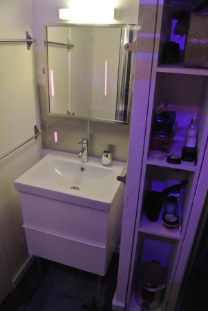 La salle de bain avec nombreux rangements sous le lavabo + dans la colonne de droite
